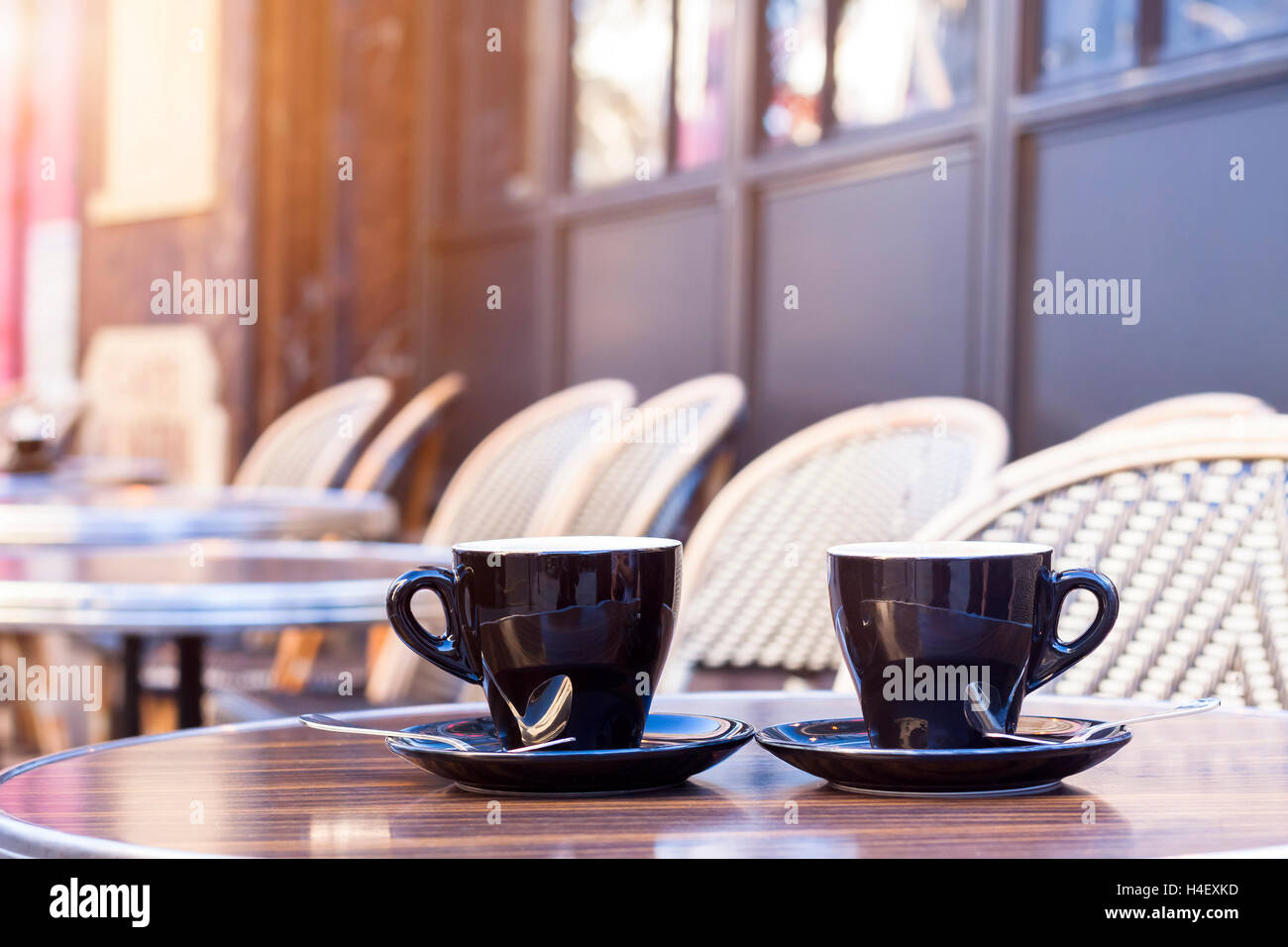 Dos tazas de café en el restaurante de la terraza con sol de la tarde Foto de stock