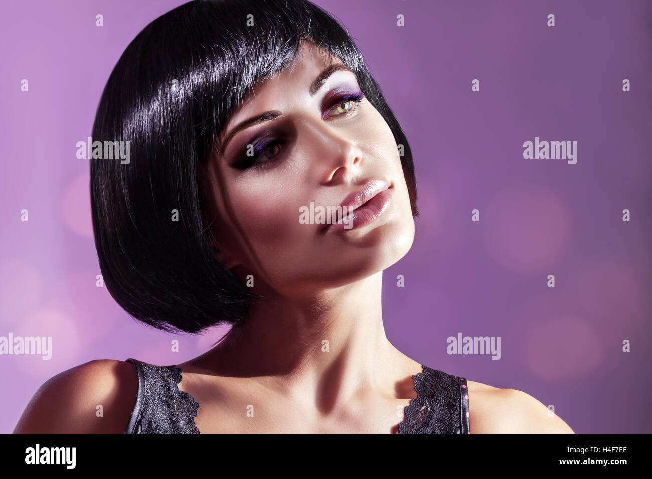 Retrato de una joven y bella mujer de más fondo púrpura, modelo atractivo con un magnífico bob cortes de pelo y maquillaje brillante Foto de stock