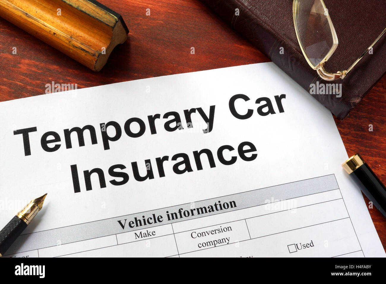 Formulario de solicitud de seguro de coche temporal en una tabla. Foto de stock