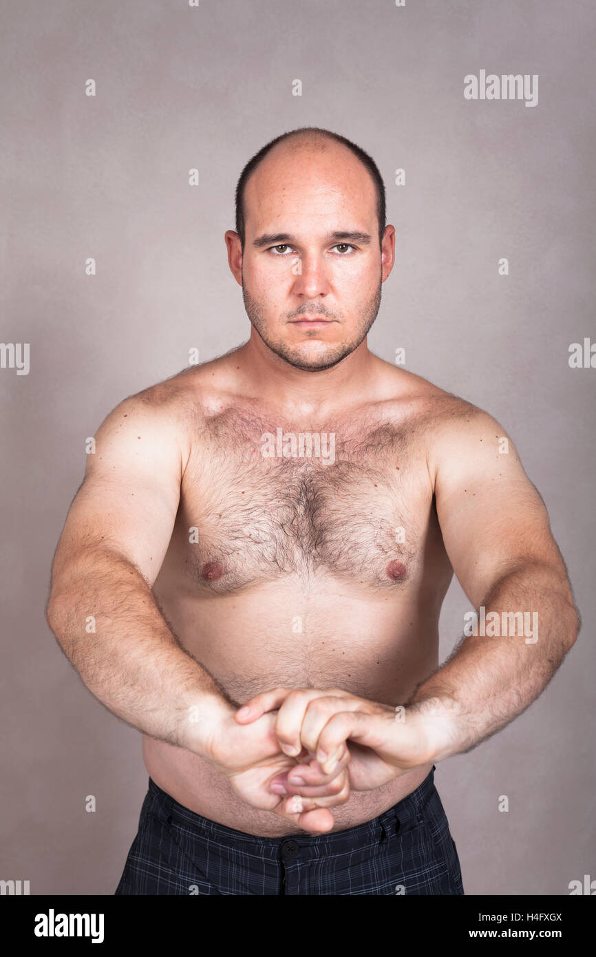 Retrato del hombre descamisado graves posando y mostrando su fuerte cuerpo. Foto de stock