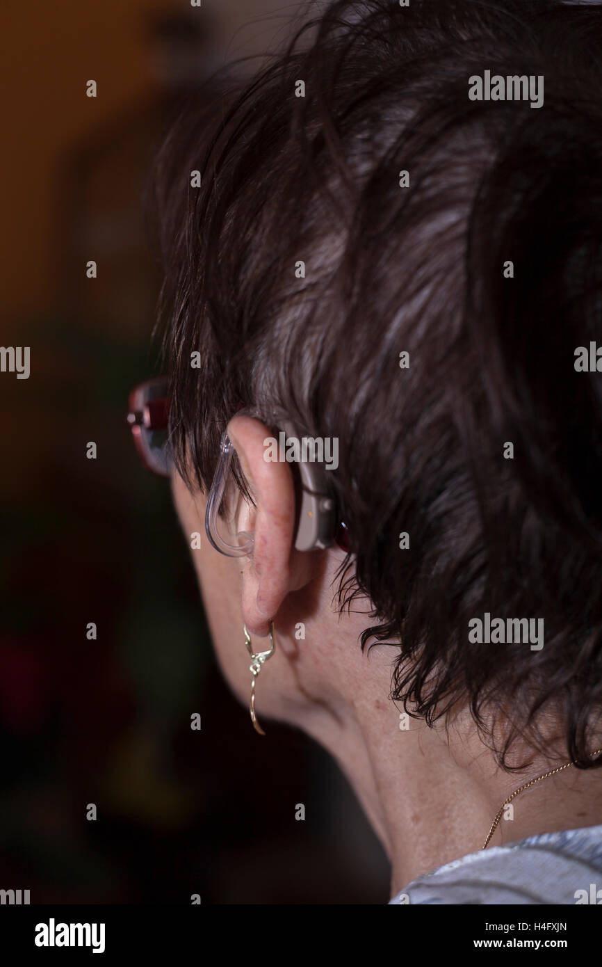 Detalle de una mujer mayor cabeza con audífonos. Foto de stock