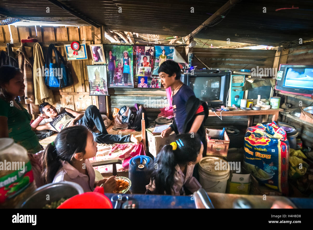 Familia dentro de un refugio de madera que construyeron como casa temporal, un año después de los terremotos y deslizamientos de tierra de 2015 en el distrito de Kavrepalanchok, Nepal. Foto de stock