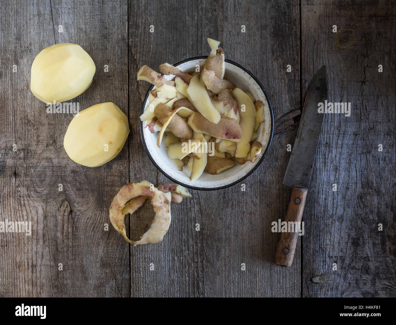 Cortar patatas en tabla de madera con patatas en metal cesta en el fondo  Fotografía de stock - Alamy