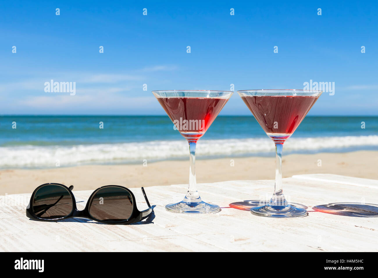 Dos cócteles y gafas de sol en un restaurante de playa, ocio tropical Foto de stock