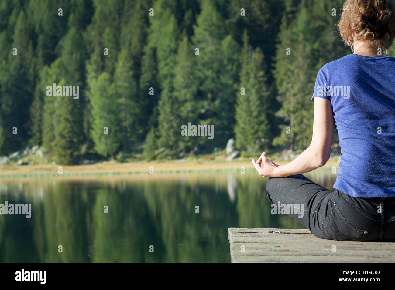Pretty Woman practicando yoga en un lago Foto de stock