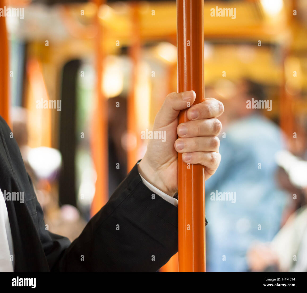 Persona sosteniendo el mango. Transporte público interior Foto de stock