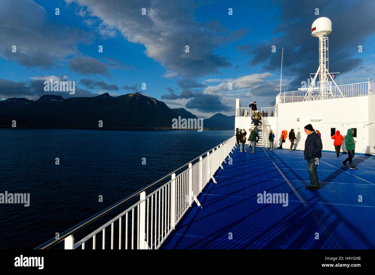 Los turistas de barco acercándose a la costa de fiordos orientales, Islandia, en el Atlántico Norte, Europa Foto de stock