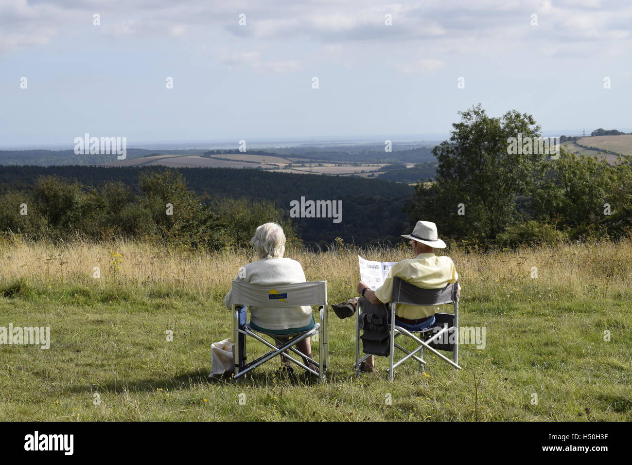 Una pareja de ancianos, relajarse en las sillas de camping en el South Downs Foto de stock