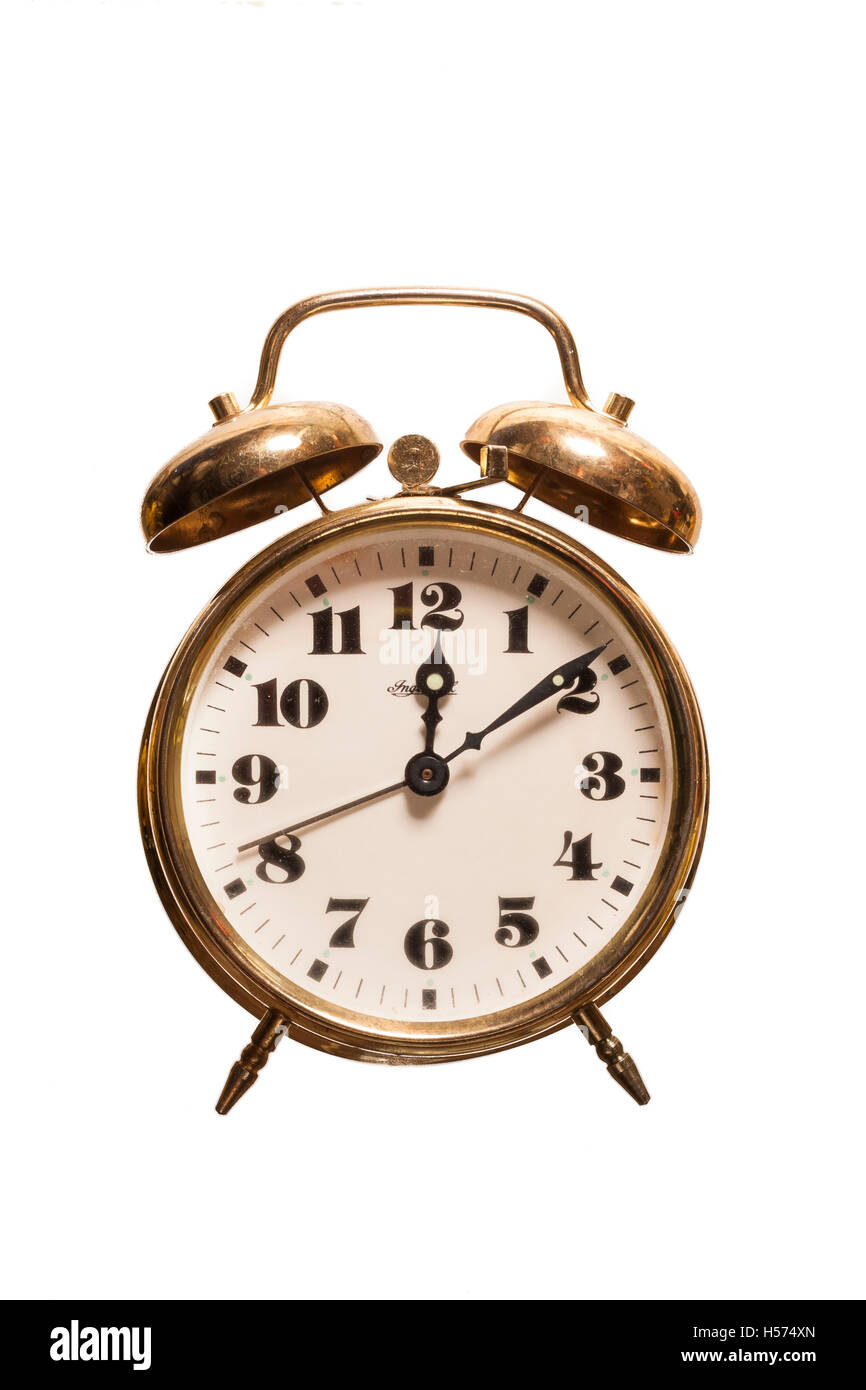 Reloj despertador antiguo metal dorado sobre fondo blanco aislado. Vista de  frente Stock Photo