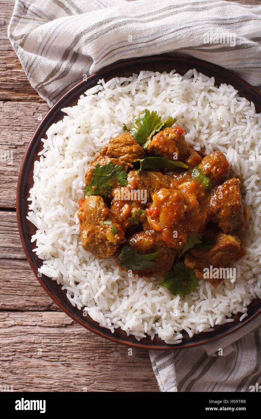 Comida india: Madras ternera con arroz basmati en la tabla cerca. vista vertical desde arriba Foto de stock