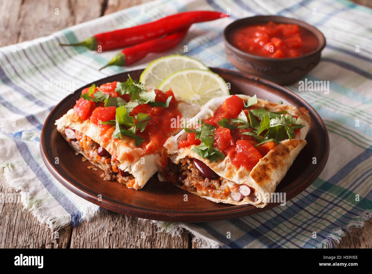 Chimichanga con carne molida, frijoles y queso de cerca en la tabla