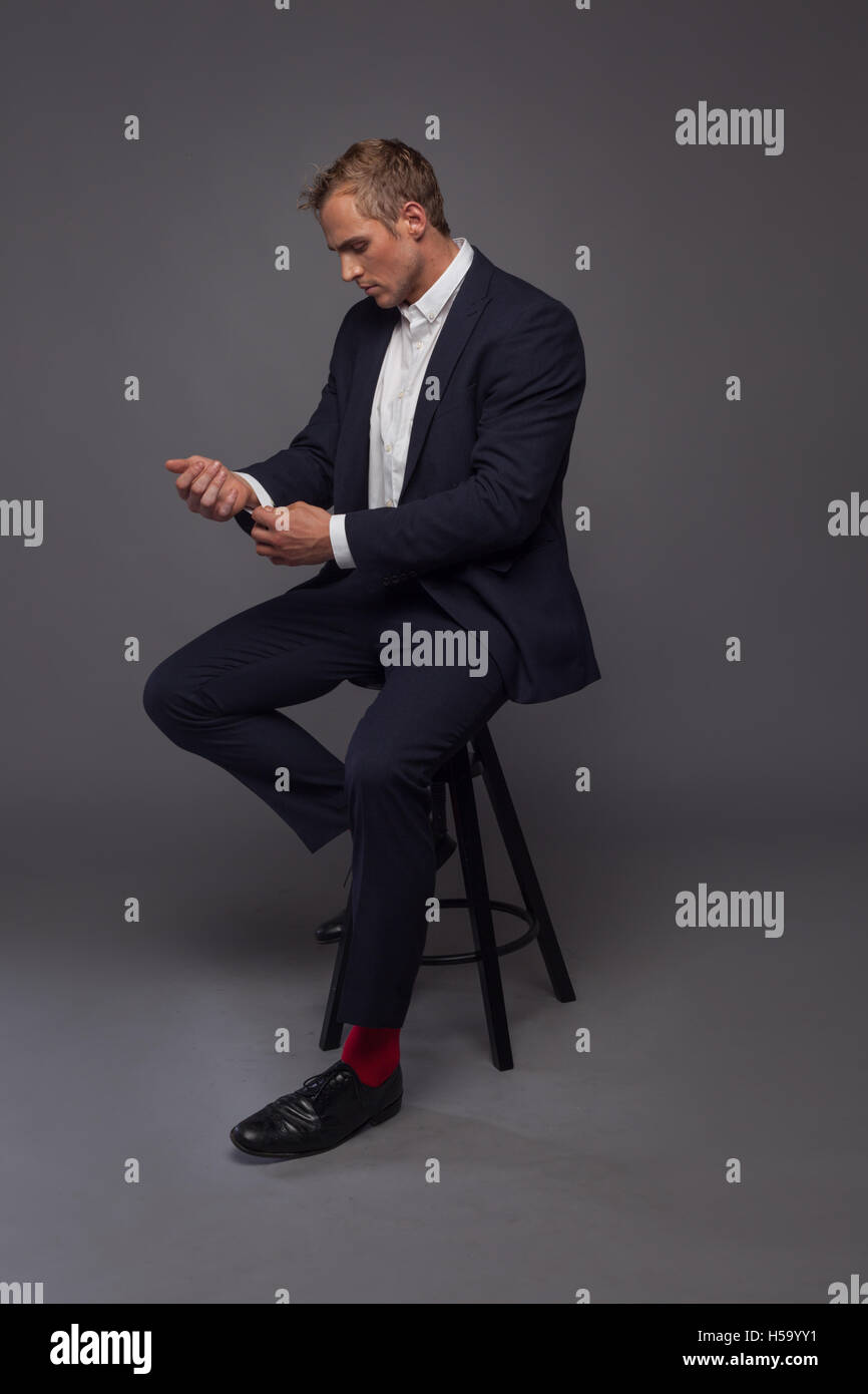 Elegante moda joven hombre de smoking sentado en la silla Fotografía de  stock - Alamy