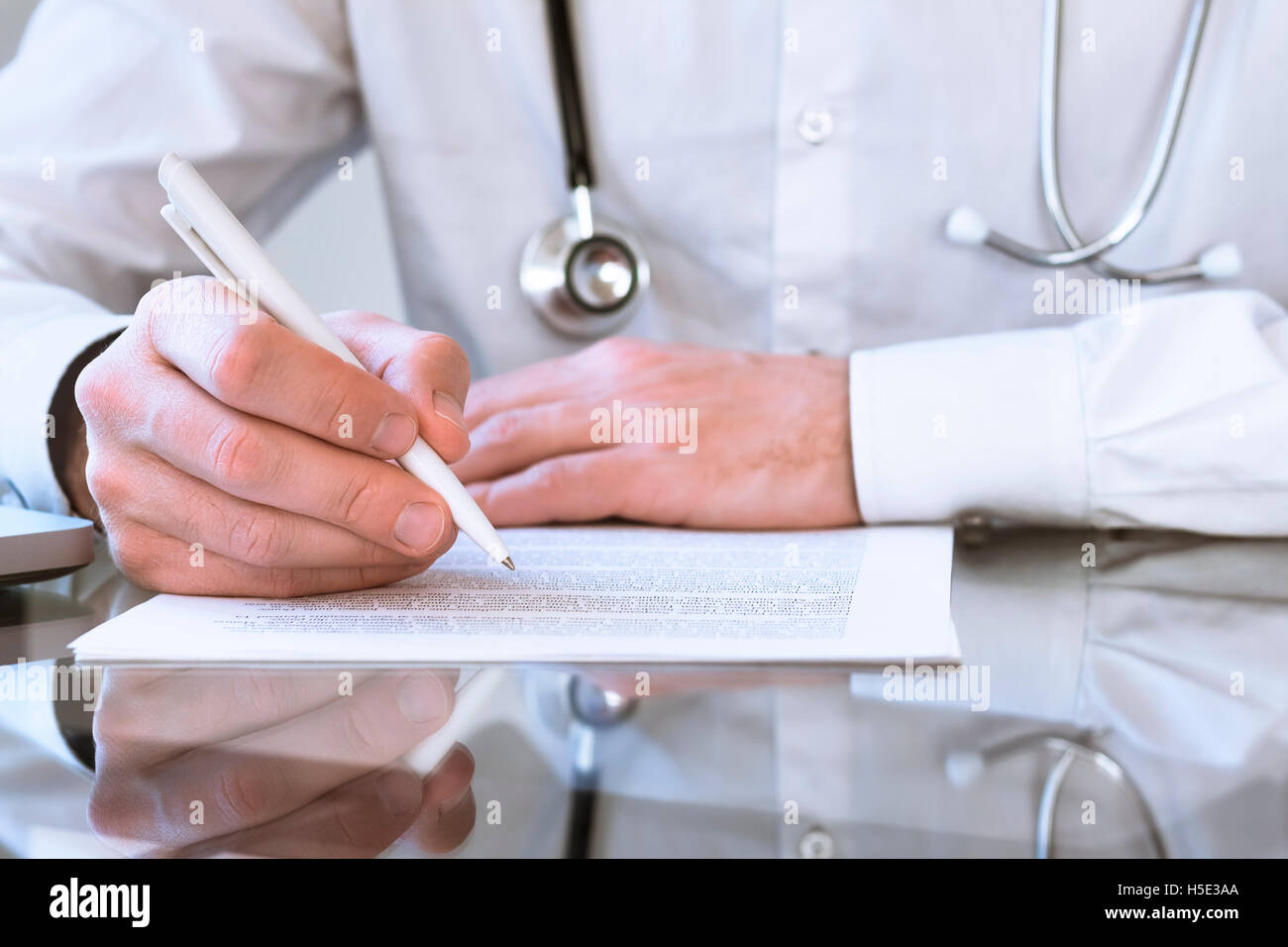 Médico varón escrito prescripción médica o certificado Foto de stock