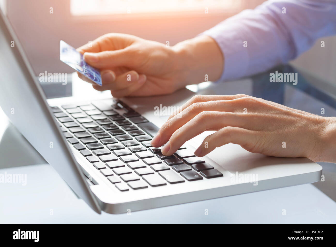 Concepto sobre el pago en línea a través de internet y el comercio electrónico, la mujer en el hogar teclear el número de tarjeta de crédito en el equipo Foto de stock