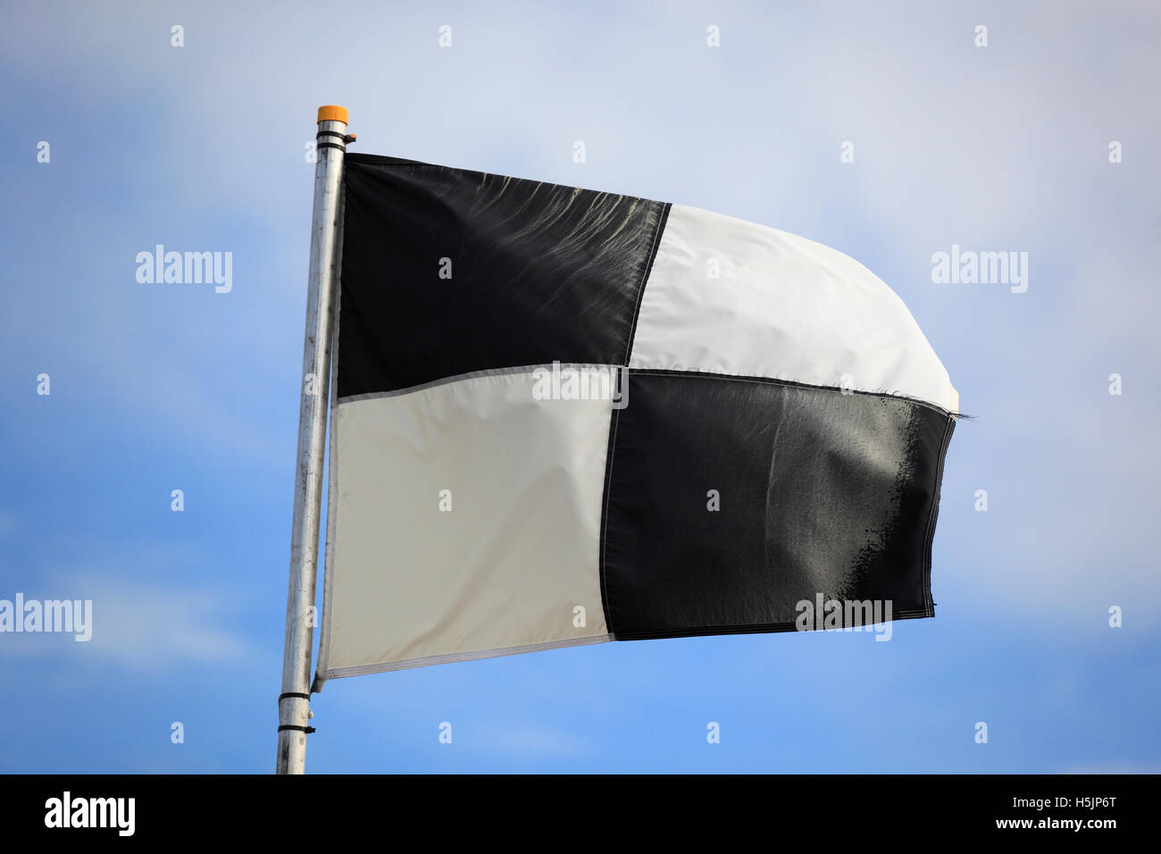Bandera a cuadros blancos y negros en la playa. Foto de stock