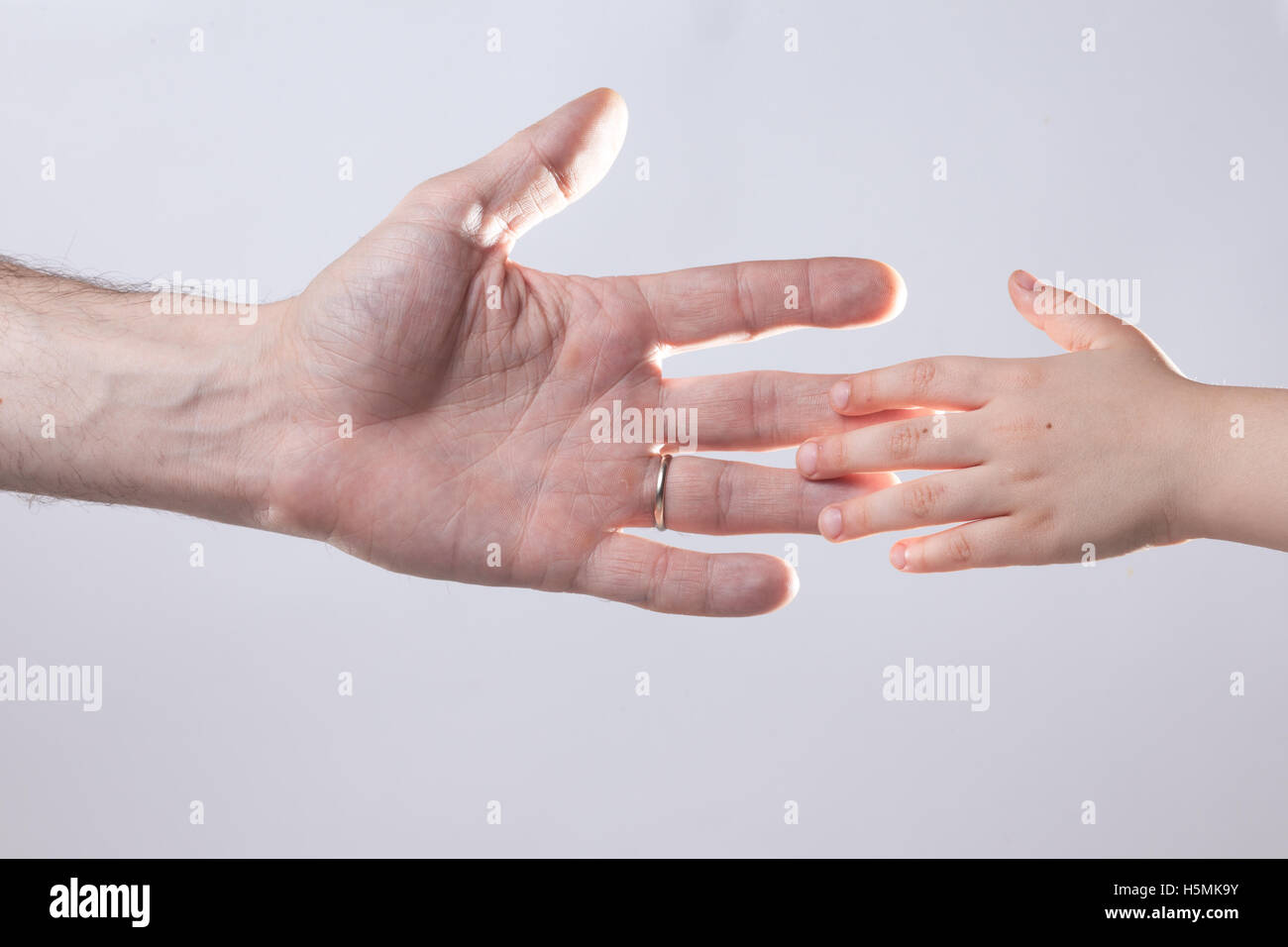 De la mano de adulto y niño toque ayuda ternura Foto de stock