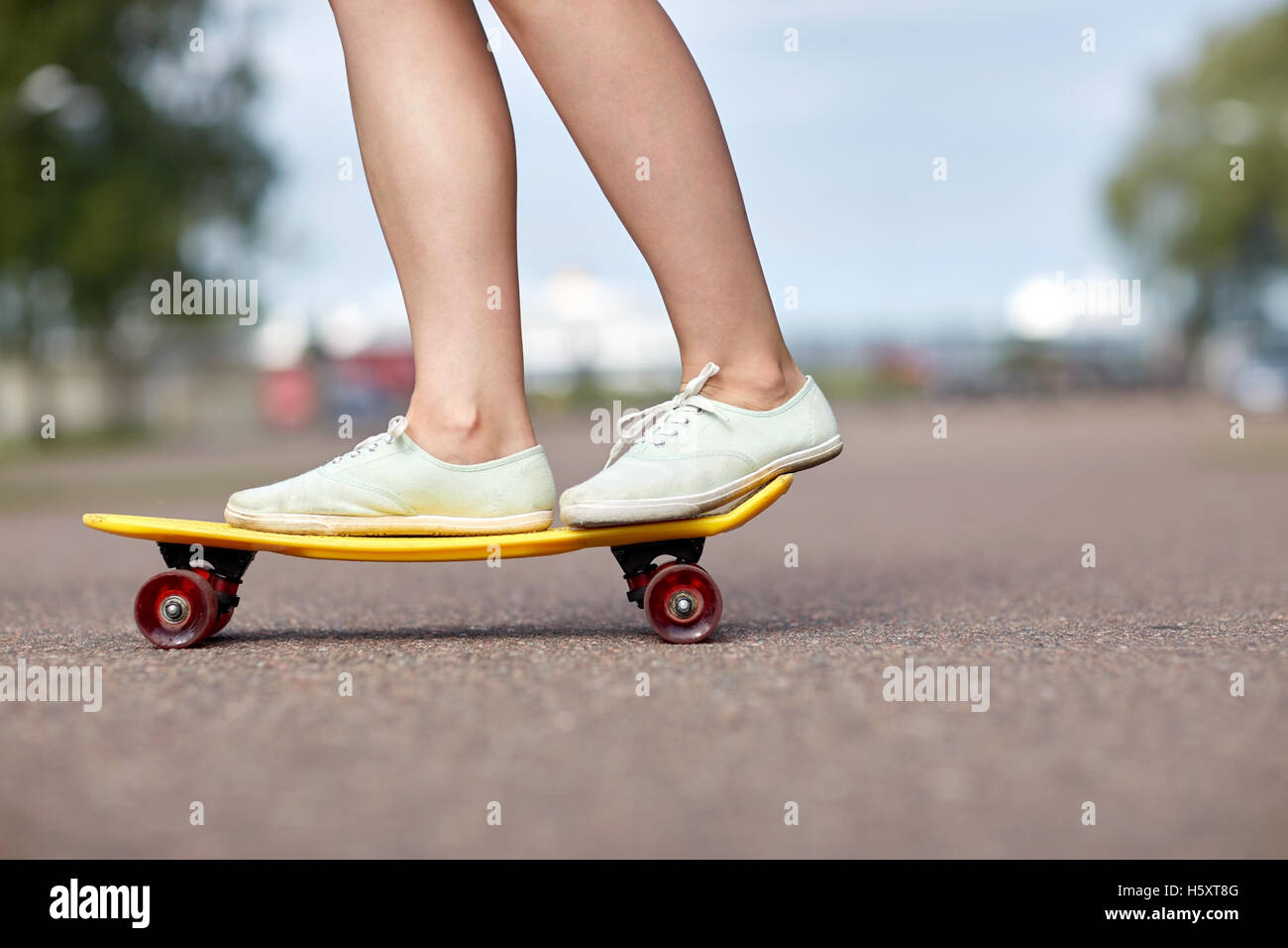 Cerca de los pies femeninos corto de equitación skateboard Foto de stock