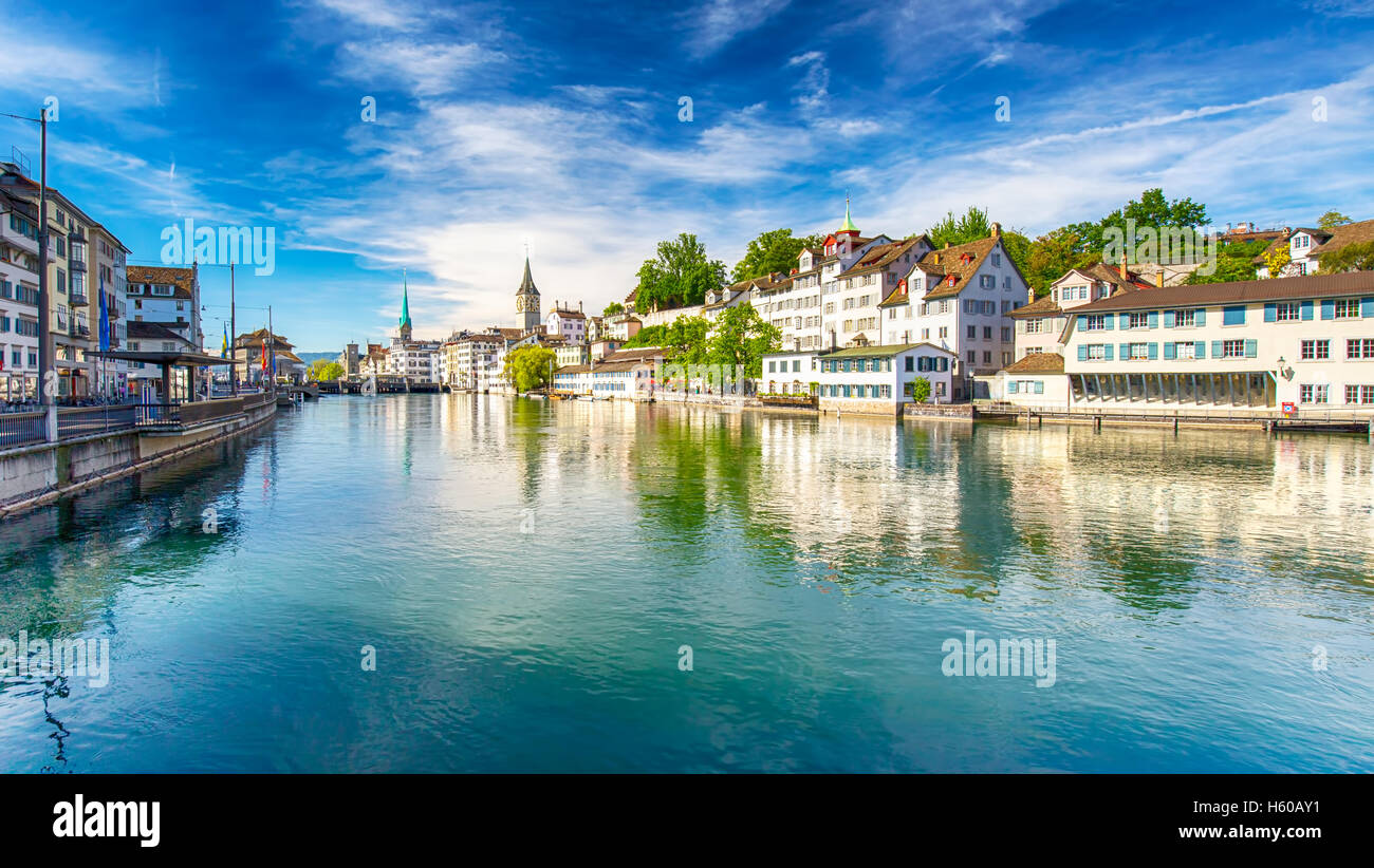 Hermosa vista del centro histórico de la ciudad de Zurich con la famosa iglesia Fraumunster y cisnes en el río Limmat, en un día soleado Foto de stock