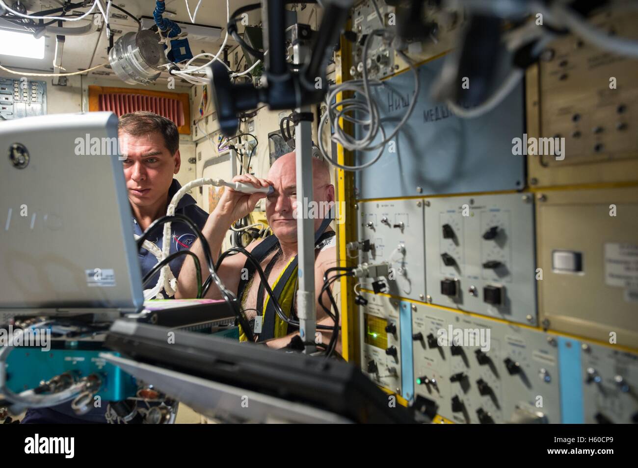Expedición de la Estación Espacial Internacional de la NASA misión 44 primera tripulación astronauta Scott Kelly (derecha) utiliza una presión negativa en la parte inferior del cuerpo Chibis dispositivo mientras el cosmonauta ruso Mikhail Kornienko médicamente ayuda a monitorear y medir sus fluidos corporales, el 16 de septiembre del 2015, mientras que en la órbita de la tierra. Foto de stock