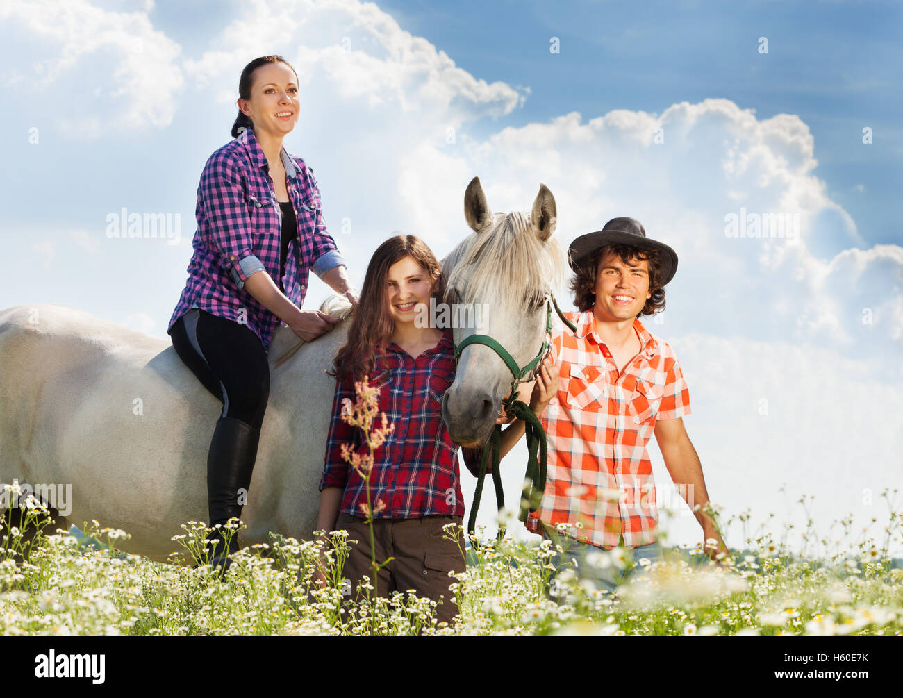 Tres jóvenes va montar a caballo en día soleado Foto de stock