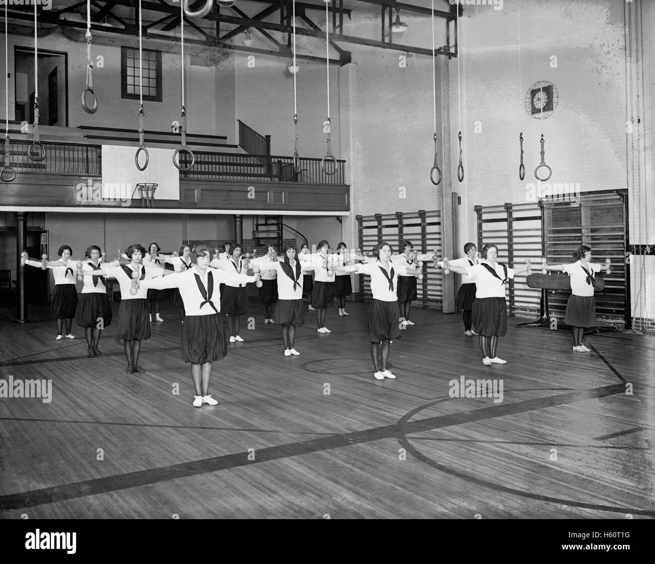 Las chicas haciendo ejercicio en el gimnasio, en la región oriental de High School, en Washington DC, EE.UU. National Photo Company, 1910's Foto de stock
