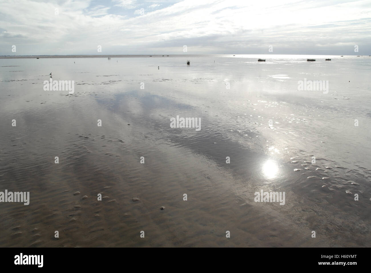 Estratocúmulos blanco húmedo, marea baja playa de arena blanca con vista reflejo del sol, mirando hacia el sur, Fairhaven, Lytham St Annes, RU Foto de stock