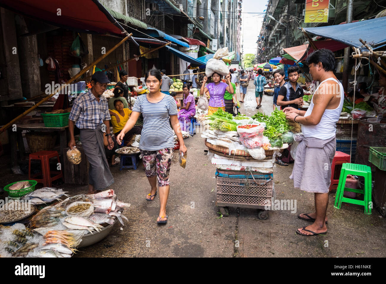 La gente en un mercado callejero en el centro de Yangon. Foto de stock