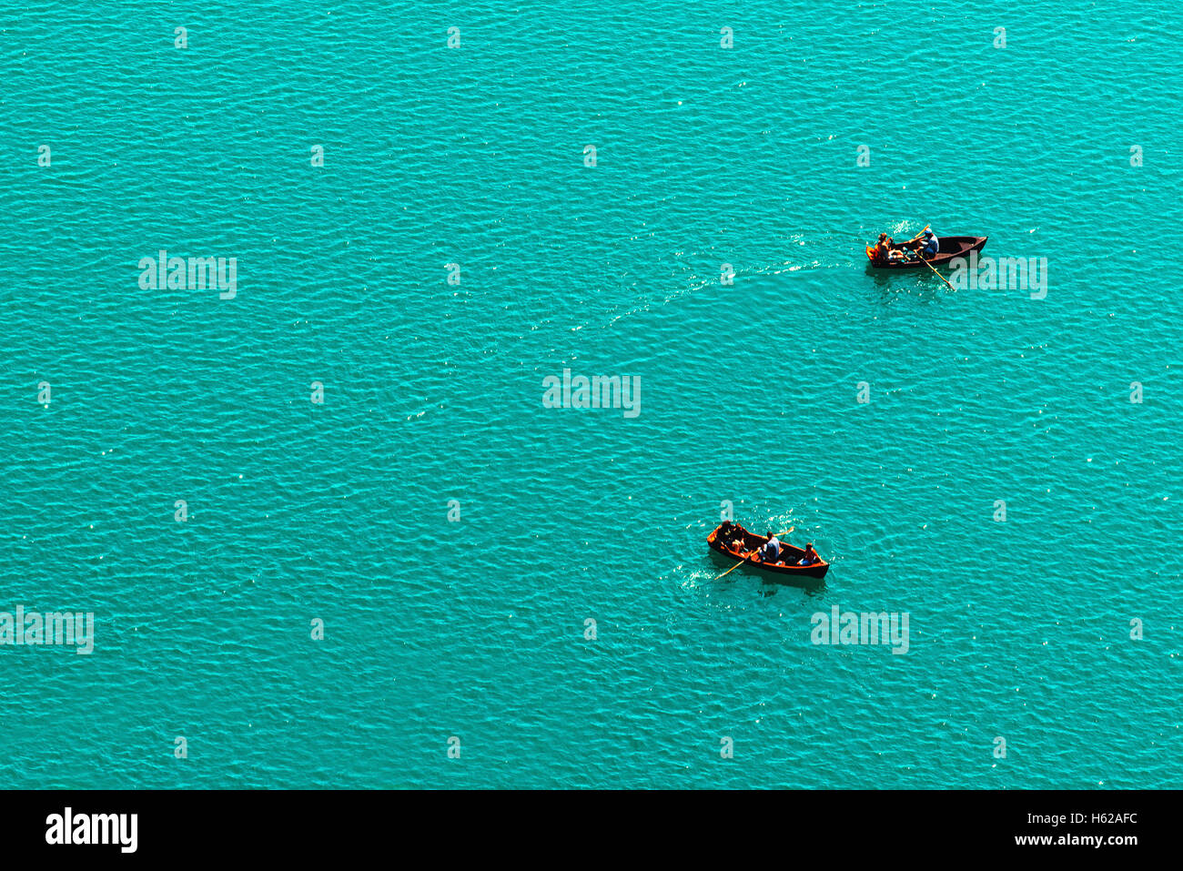 Embarcaciones de remo en el lago, disfrutando del verano y actividades al aire libre, vista aérea del pueblo irreconocible y superficie de agua dulce como cop Foto de stock