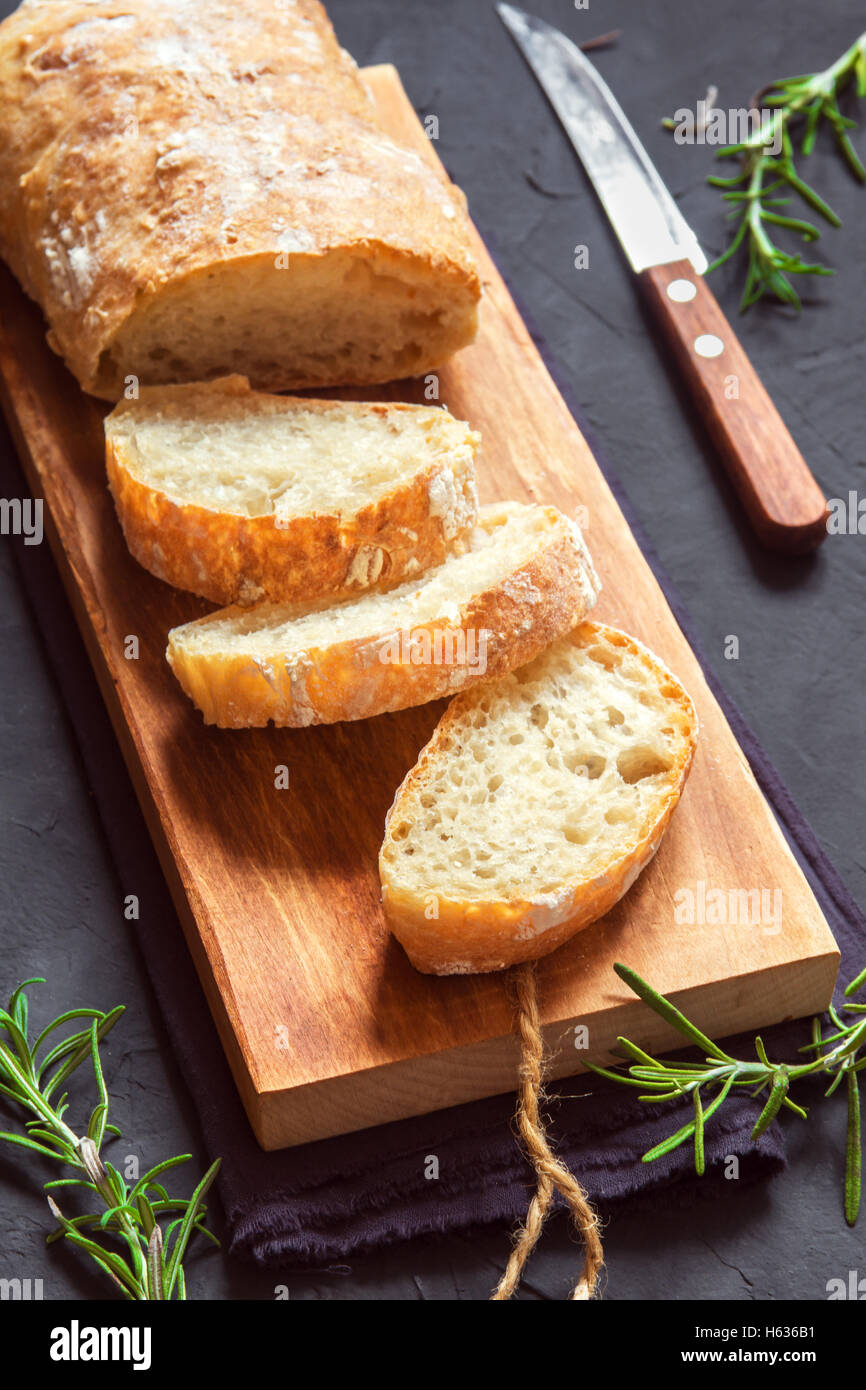 Pan italiano Ciabatta y Rosemary sobre fondo negro - fresco pan casero, panadería Foto de stock