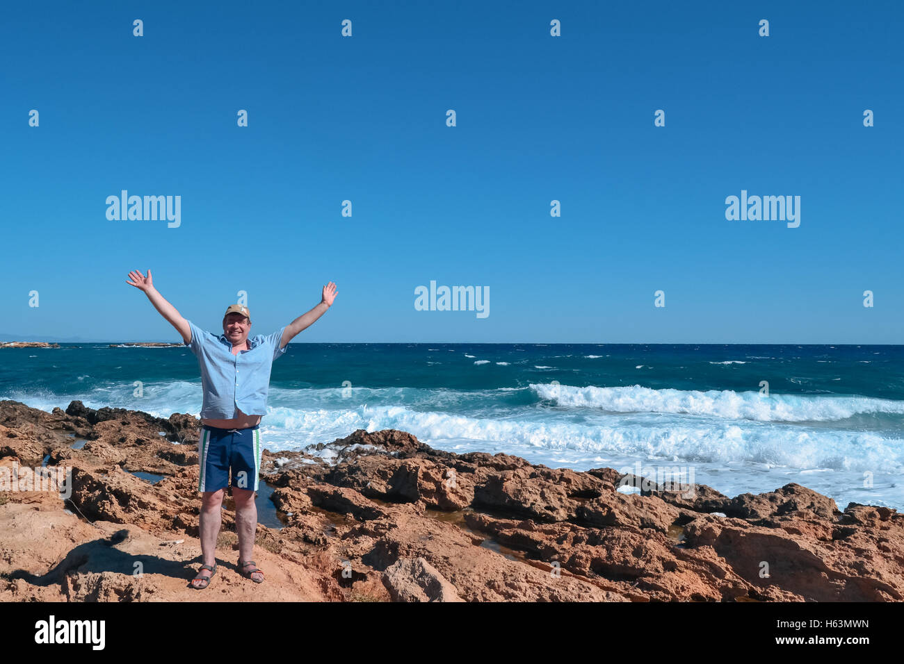 Hombre de mediana edad disfrutando de la cálida brisa del mar Foto de stock
