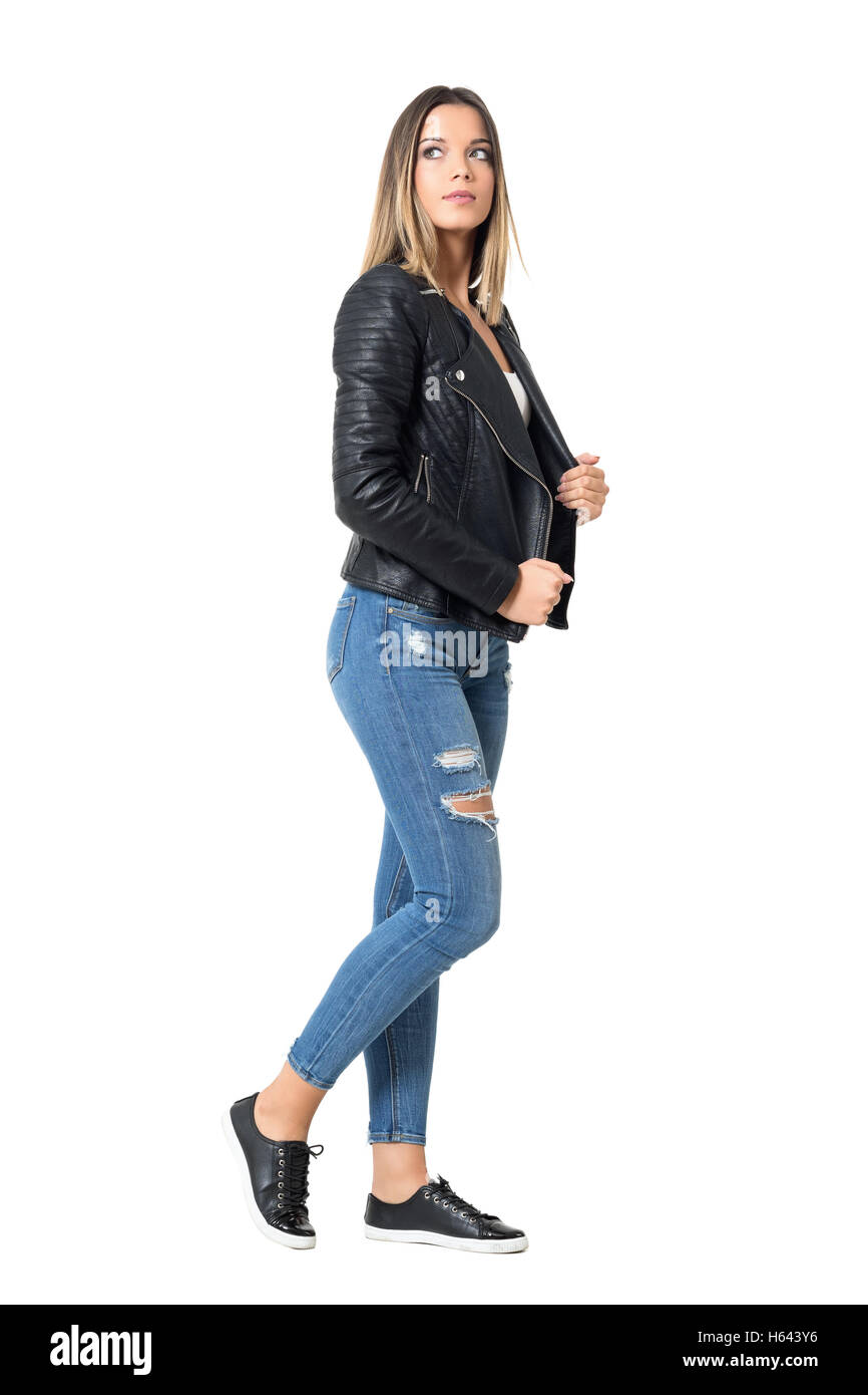Vista lateral de la joven mujer hermosa en jeans rajados y chaqueta negro  mirando hacia arriba. Longitud de cuerpo completo retrato aislado en blanco  Fotografía de stock - Alamy