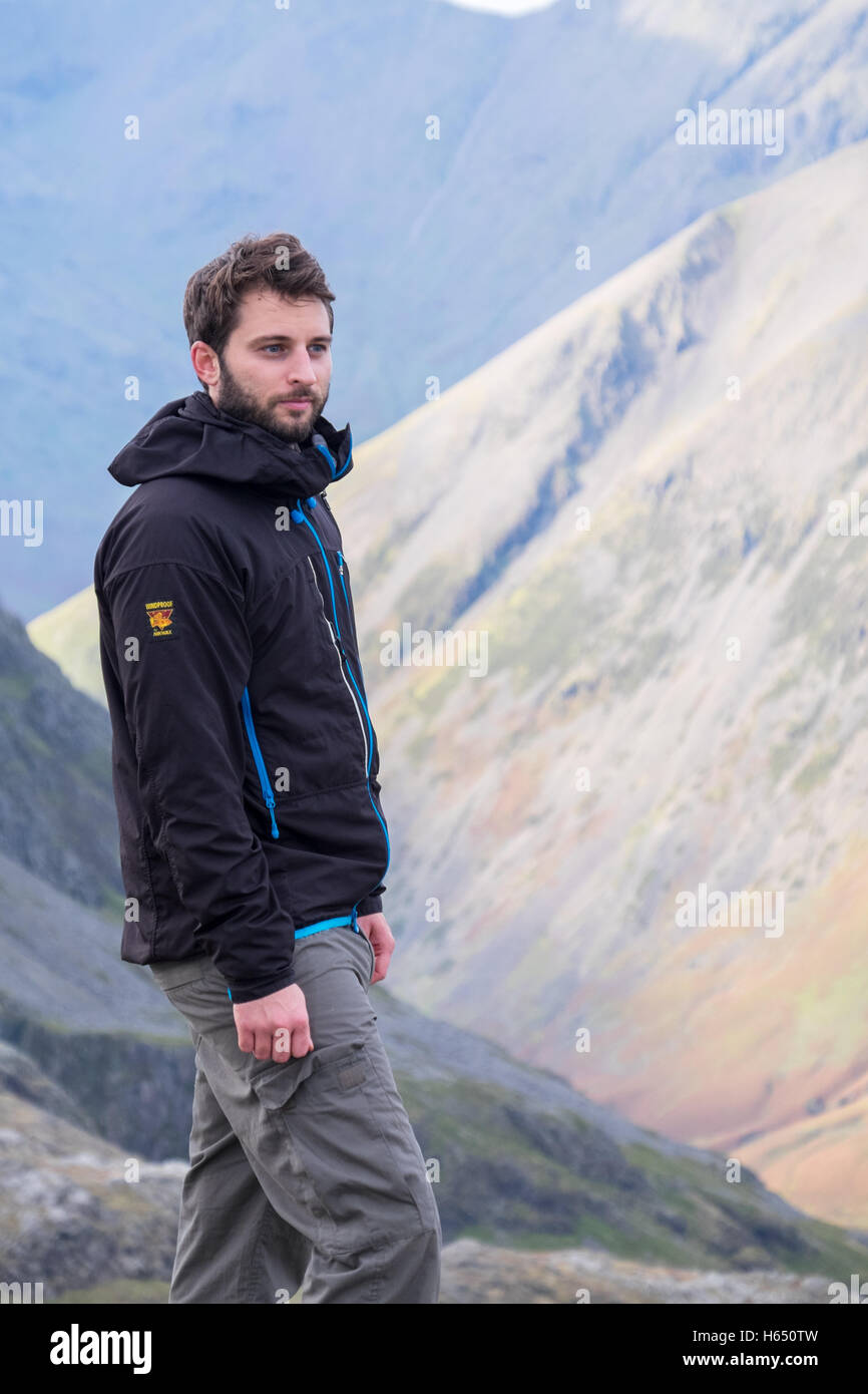 Macho en su veintipico senderismo en el Lake District, llevaba una chaqueta del páramo Foto de stock