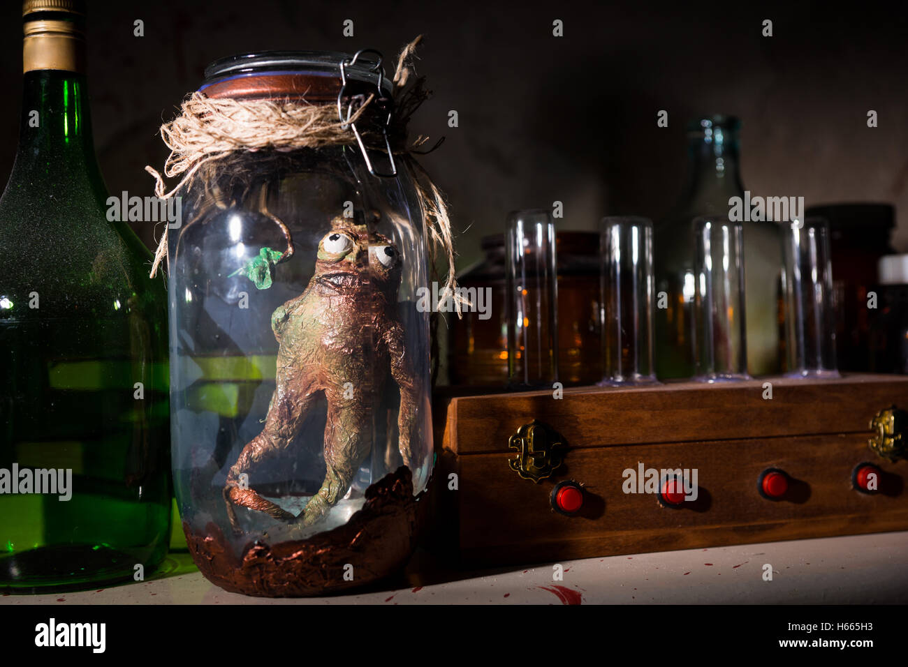 Criatura muerta con los ojos saltones dentro del frasco cerrado con una cuerda en una habitación oscura Foto de stock