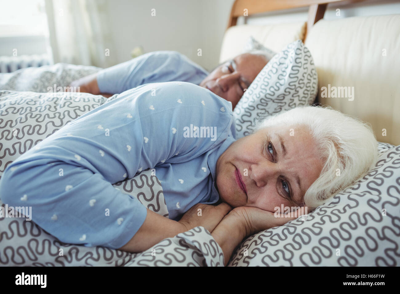 Mujer despierta en la cama superior Foto de stock
