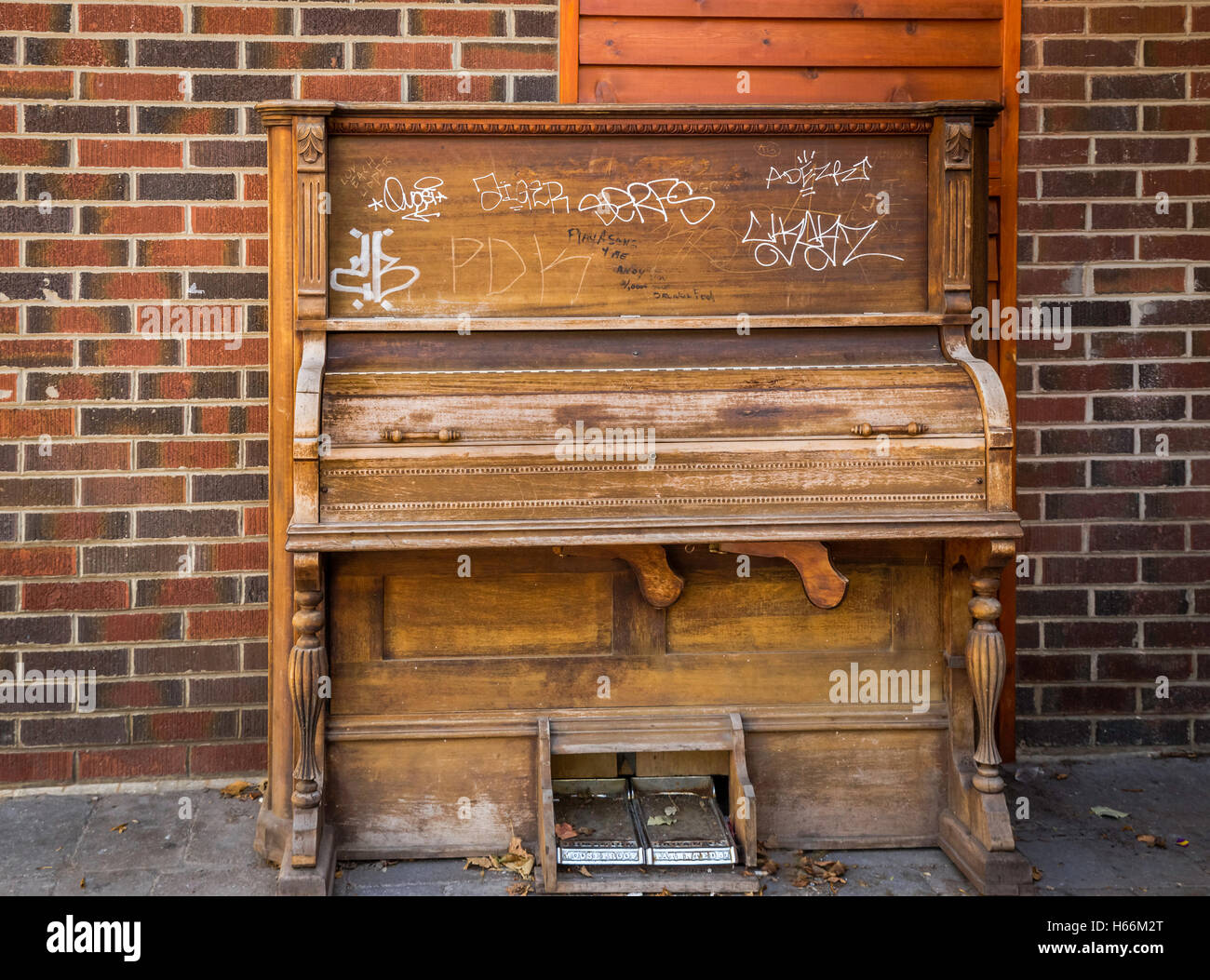 Antiguo reproductor de piano con pintadas contra una pared de ladrillos  Fotografía de stock - Alamy