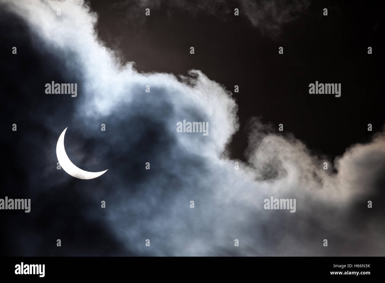 Eclipse solar parcial a través de las nubes Foto de stock