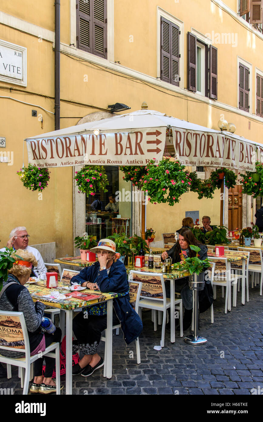 Los turistas sentados en mesas en el exterior de un restaurante pizzería de Roma, Lazio, Italia Foto de stock