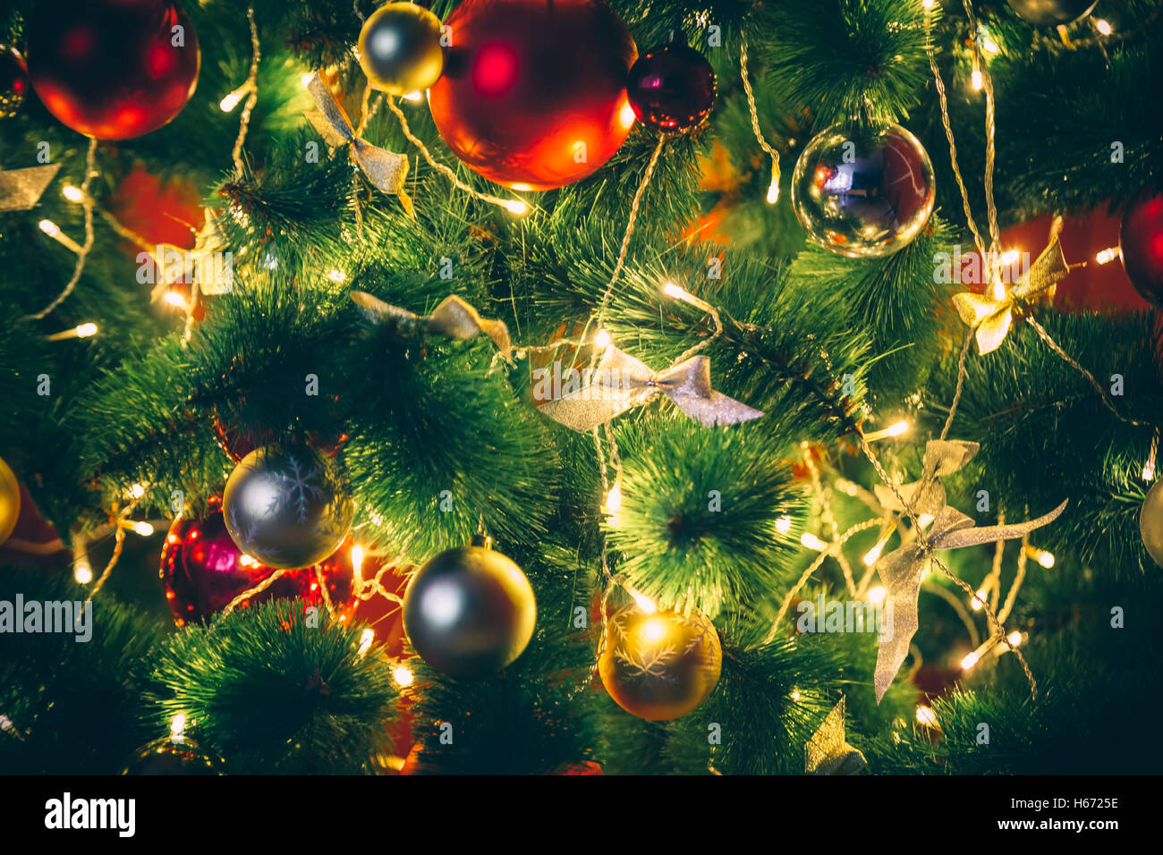 Hermoso árbol de navidad decorado con rojo y chucherías goldish y Garland, en el nuevo año. La idea de fondo de postales. Foto de stock