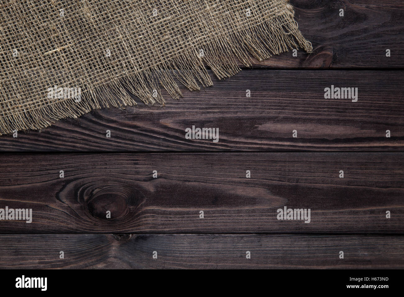 Tela de arpillera sobre fondo de madera Foto de stock