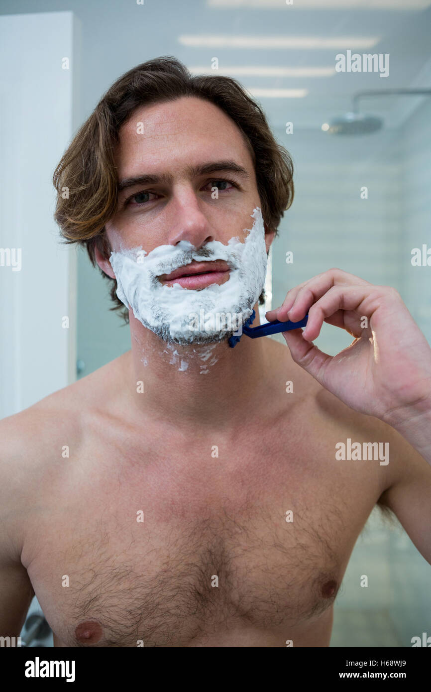 Hombre utilizando una navaja para afeitarse la barba off Foto de stock