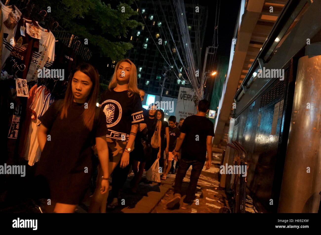 Las mujeres caminan en línea en la acera, junto a la estación de BTS DE TUERCA, todos visten de negro en honor del difunto Rey de Tailandia Bhumibol Adulyadej. Foto de stock