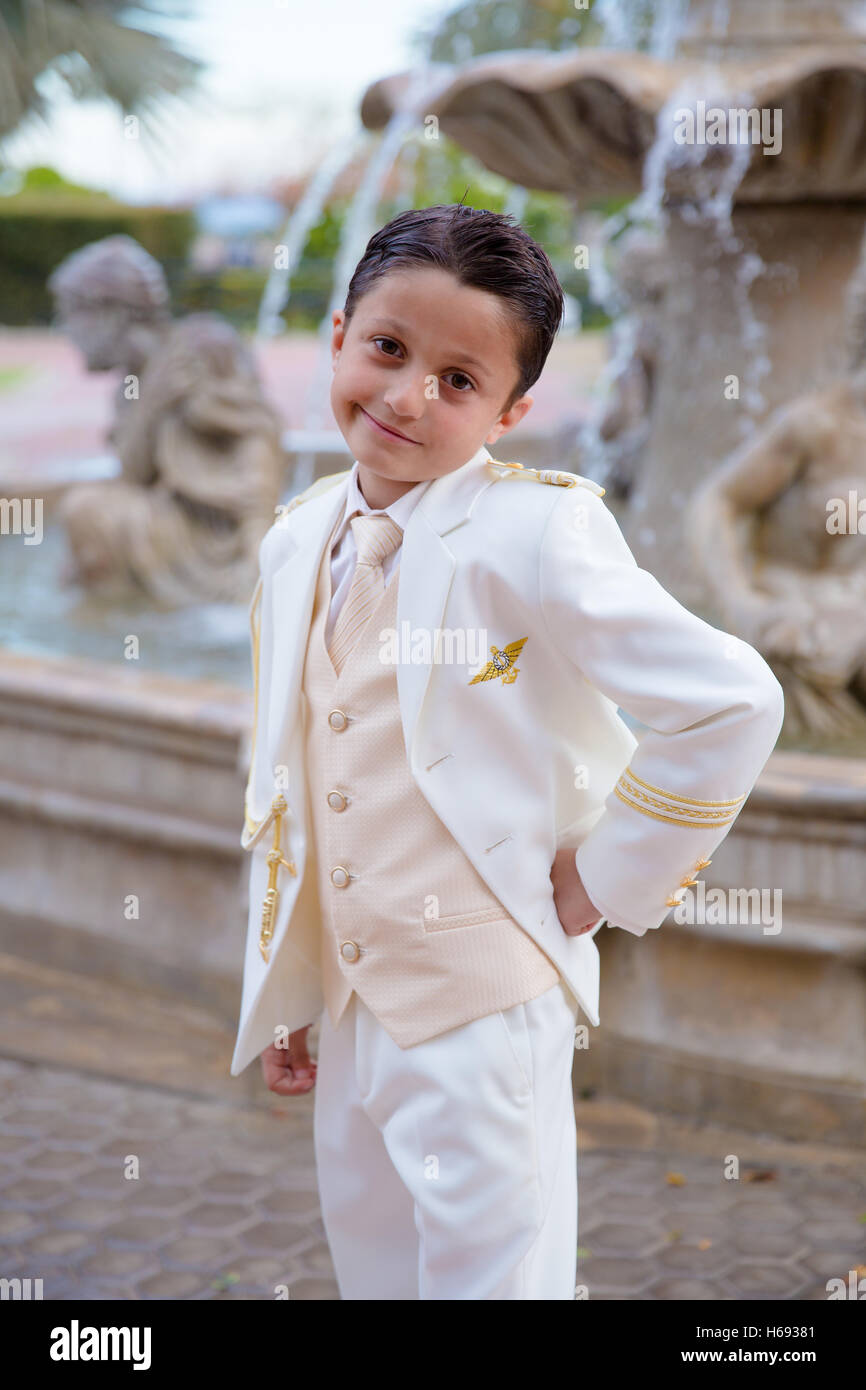 Joven con traje de marinero blanco sonriente en su Primera Comunión de pie  en frente de una fuente Fotografía de stock - Alamy