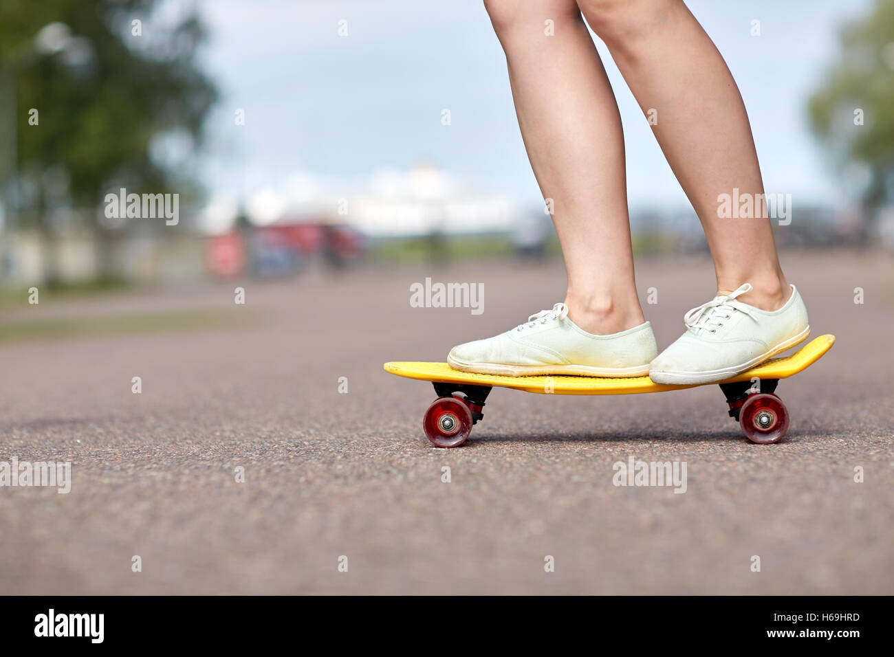 Cerca de los pies femeninos corto de equitación skateboard Foto de stock