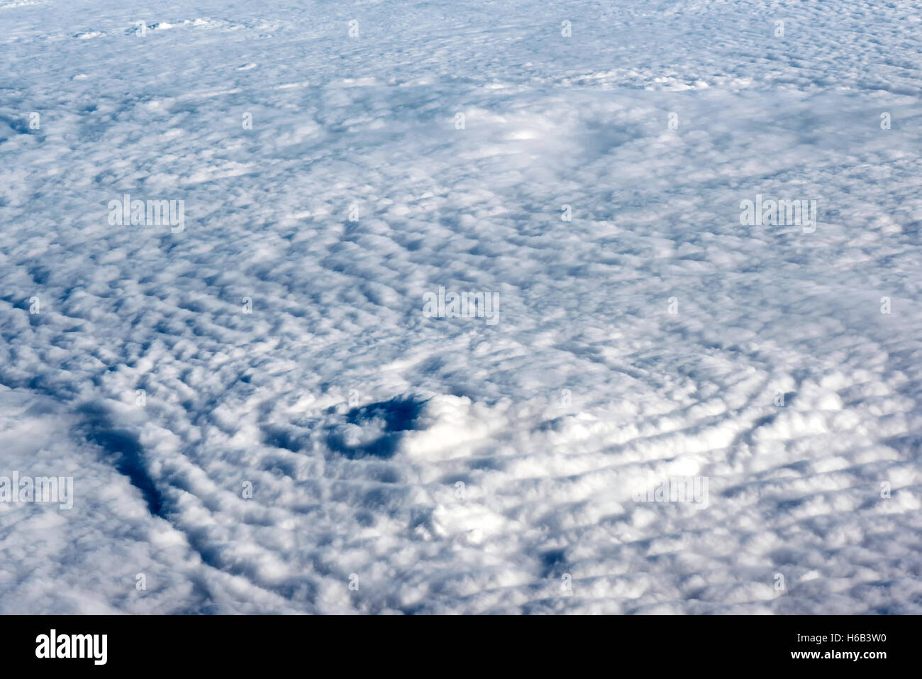 Volando por encima de una densa capa de nubes blancas en el sol en un viaje, el tiempo y el clima concepto Foto de stock