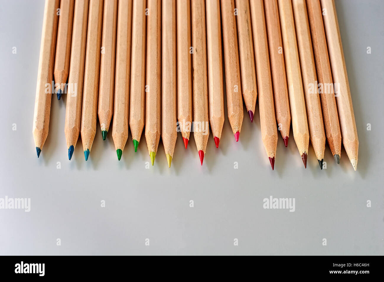Fila escalonada de madera natural de lápices de colores Foto de stock