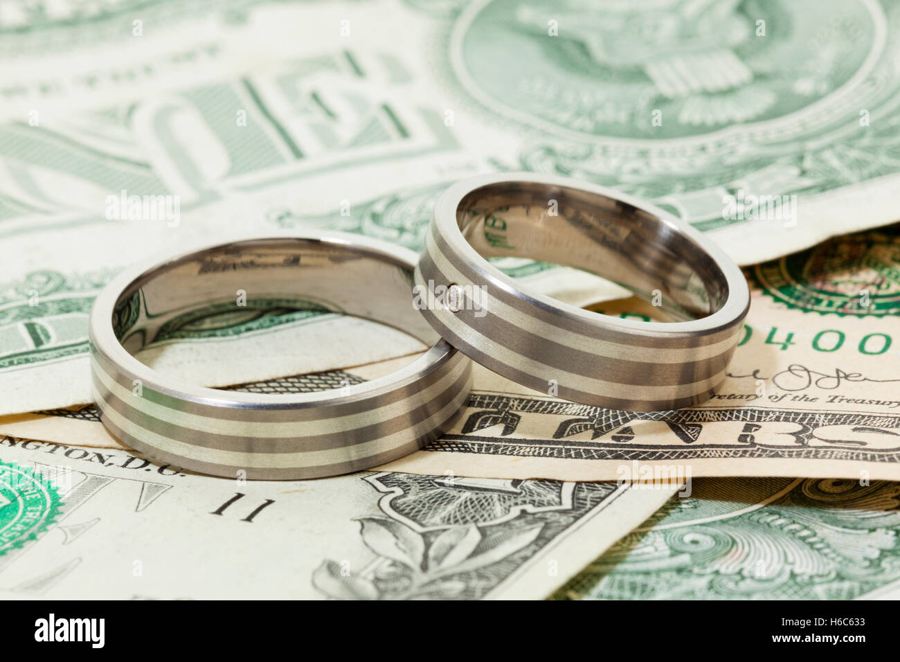 Par de anillos de compromiso o boda en billetes de dólar Foto de stock