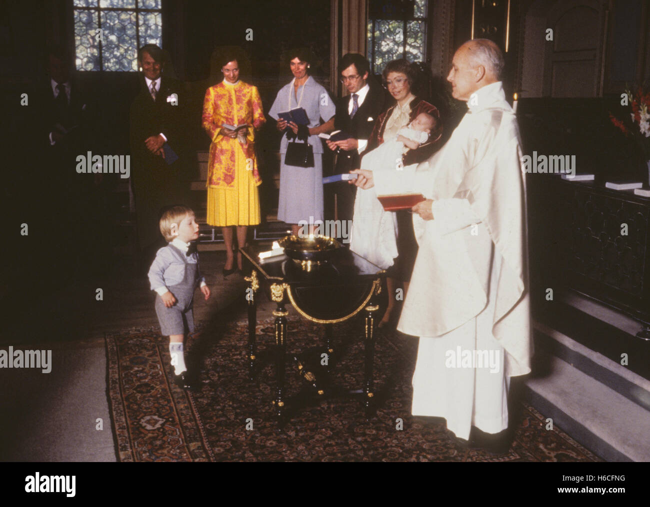 La princesa Christina y su esposo Tord bautizar a su segundo hijo Oscar mientras el hijo mayor Gustav observando con interés Foto de stock
