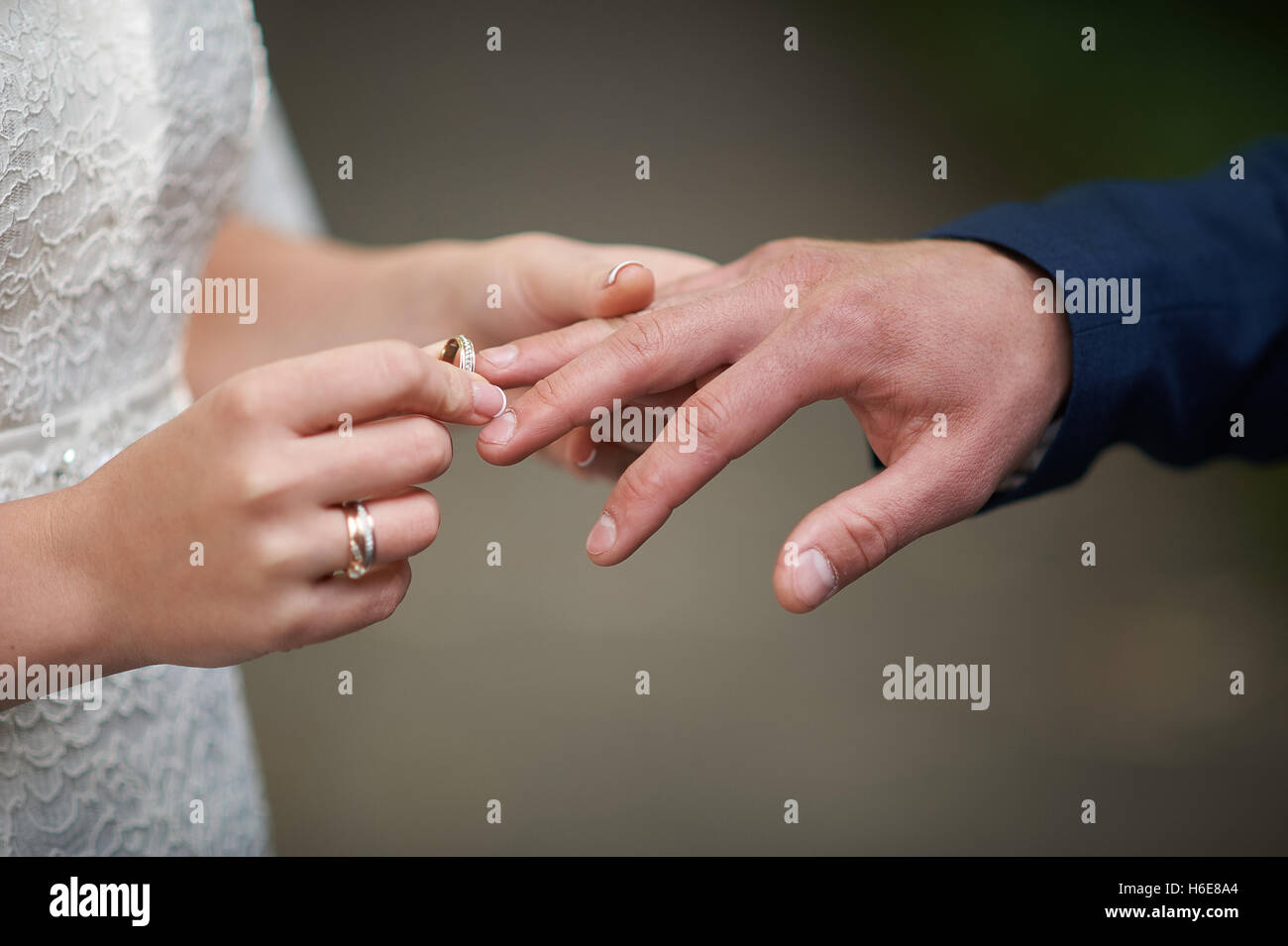 Novia lleva un anillo de bodas en el dedo del novio Foto de stock