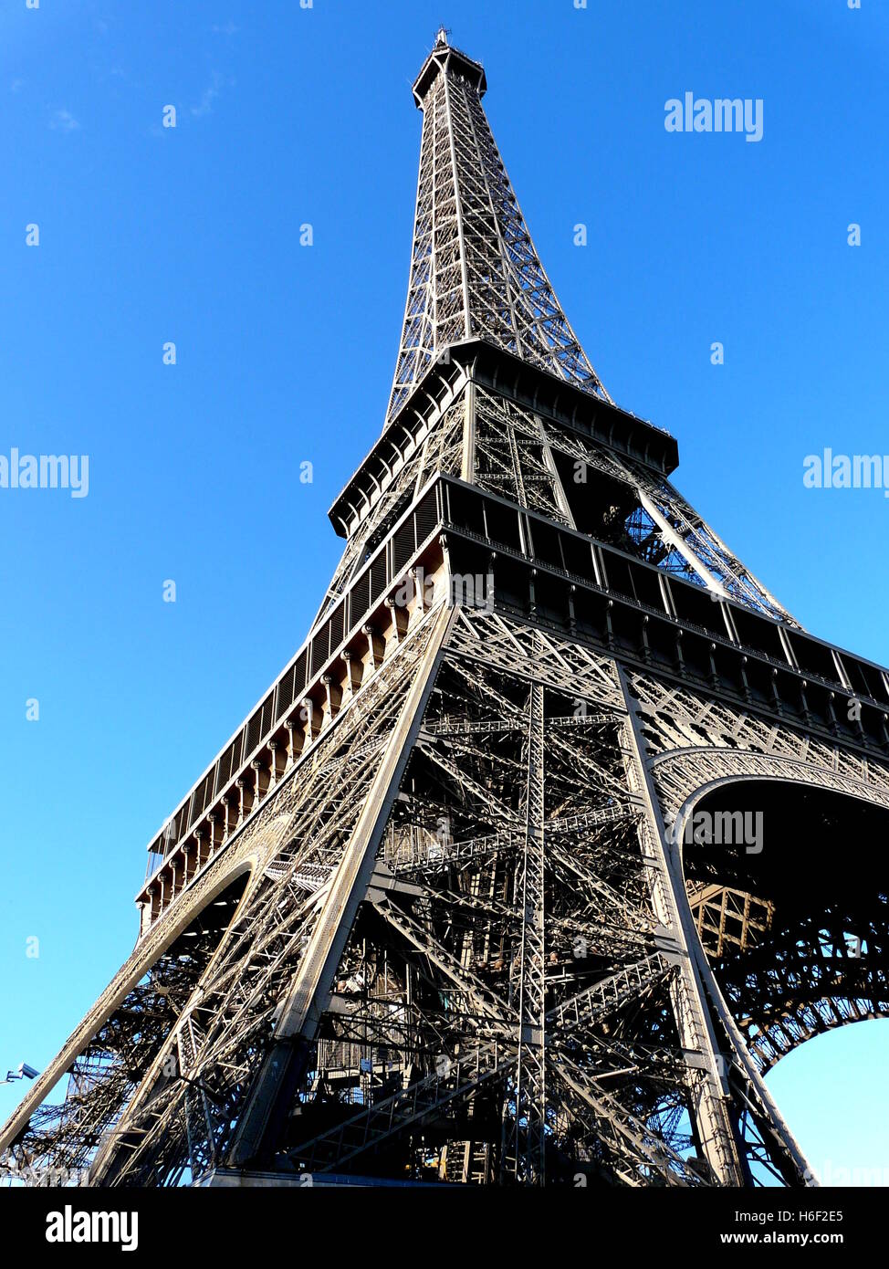 Torre Eiffel en París, visto desde debajo de una de las piernas de hierro, sobre un cielo azul brillante de septiembre. Foto de stock