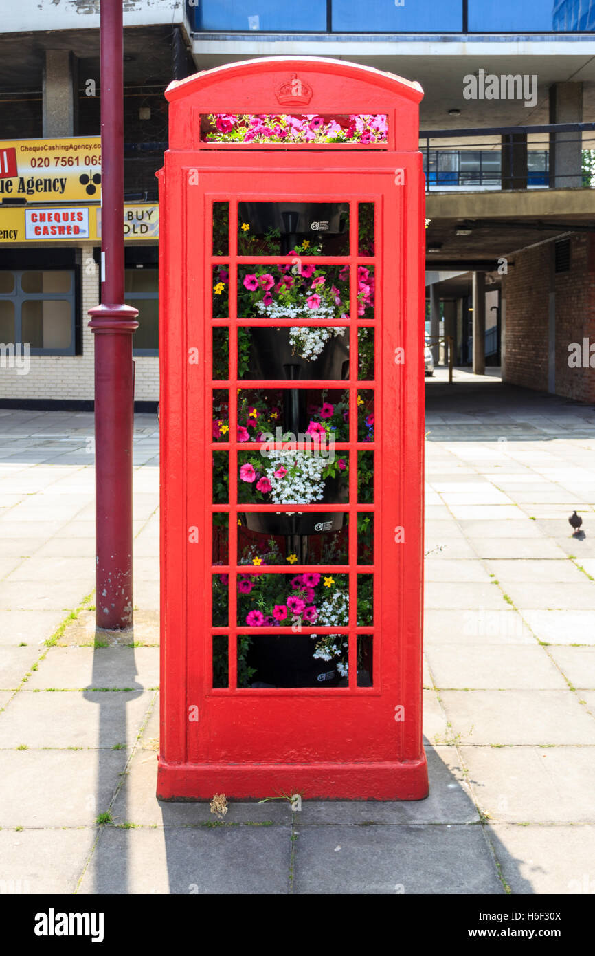 Una caja de teléfono K6 británica roja no funcional, diseño por Sir Giles Gilbert Scott, ahora llena de flores, Archway, Londres del Norte, Reino Unido Foto de stock